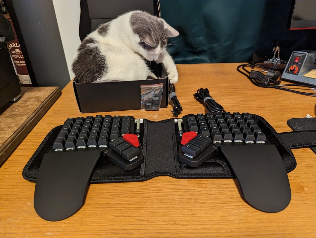 Wrist rests unfolded and taken out of the carrying case. Cat plays with cable and is quickly scolded.